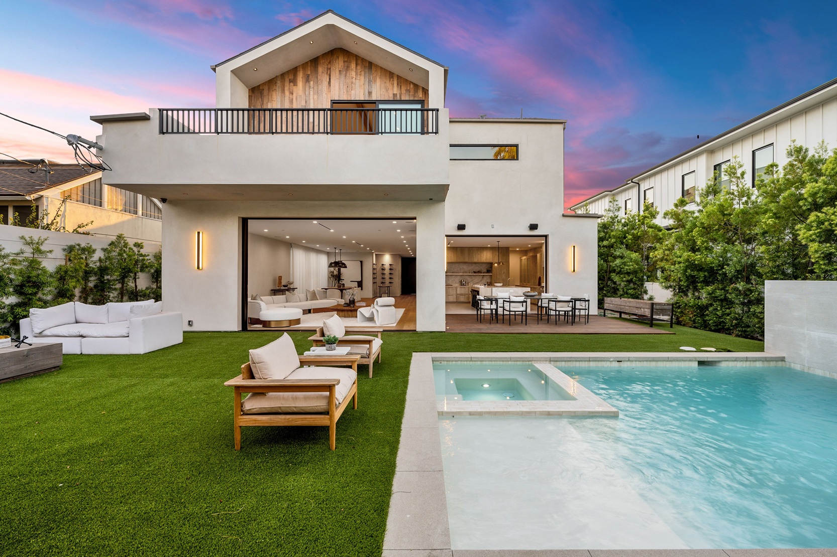 Modern two-story house with a wooden facade illuminated by the sunset